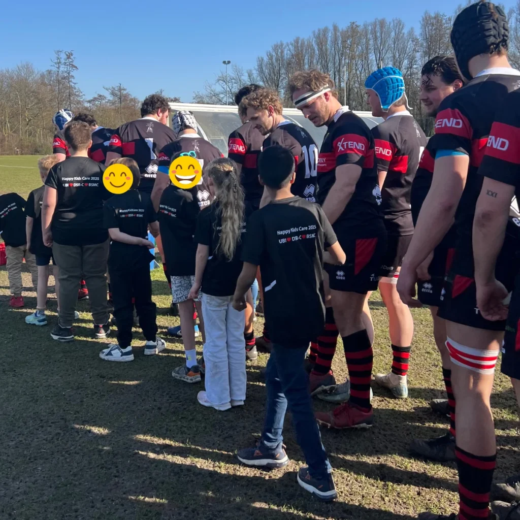 Kinderen met autisme en ADHD lopen trots het veld op met de rugbyspelers van het eerste team van DSR-C, een magisch moment.